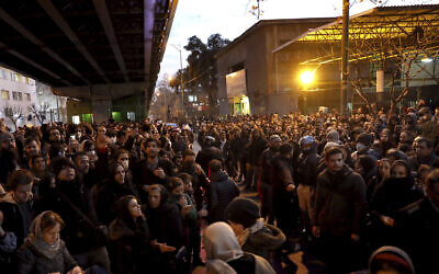 People gather for a candlelight vigil to remember the victims of the Ukraine plane crash, at the gate of Amri Kabir University that some of the victims of the crash were former students of, in Tehran, Iran, Jan. 11, 2020  (AP Photo/Ebrahim Noroozi)
