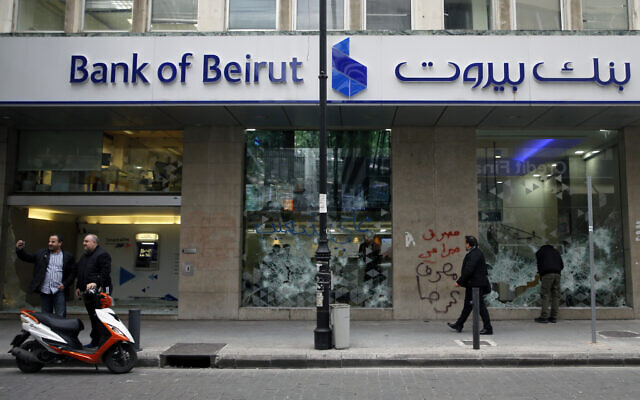 People look at the broken facade of Bank of Beirut that was smashed by anti-government protesters in Beirut, Lebanon, Jan. 15, 2020 (AP Photo/Bilal Hussein) People look at the broken facade of Bank of Beirut that was smashed by anti-government protesters in Beirut, Lebanon, Jan. 15, 2020 (AP Photo/Bilal Hussein)