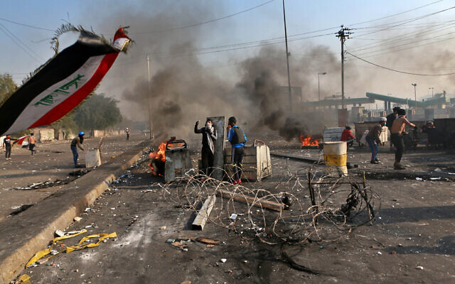 Anti-government protesters close a street while security forces use tear gas during clashes in central Baghdad, Iraq, Jan. 20, 2020 (AP Photo/Khalid Mohammed) Anti-government protesters close a street while security forces use tear gas during clashes in central Baghdad, Iraq, Jan. 20, 2020 (AP Photo/Khalid Mohammed)
