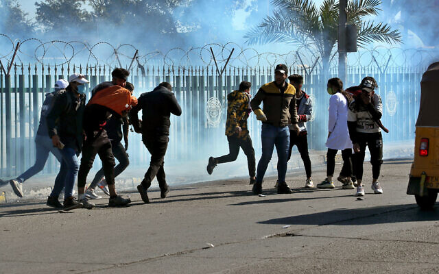 Anti-government protesters run as security forces fire tear gas to disperse them during a clash in Baghdad, Iraq on January 26, 2020. (AP Photo/Hadi Mizban) Anti-government protesters run as security forces fire tear gas to disperse them during a clash in Baghdad, Iraq on January 26, 2020. (AP Photo/Hadi Mizban)