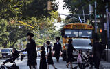 Illustrative: In this September 20, 2013 file photo, children and adults cross a street in front of a school bus in Borough Park, a neighborhood in the Brooklyn borough of New York that is home to many ultra-Orthodox Jewish families. (AP/Bebeto Matthews, File)