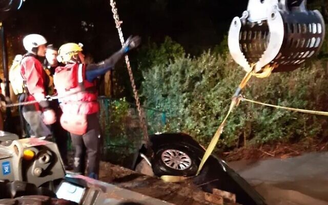 Rescue workers recover a car from flood waters in Binyamina. (Fire and Rescue Service)