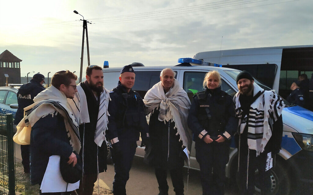 Rabbis Shabbos Kestenbaum, Ezra Seligsohn, Avi Weiss, and Jonathan Leener pose for a photo with police after protesting the location of a church in a former SS headquarters across from the former Nazi death camp Birkenau, January 27, 2020. (Yaakov Schwartz/ Times of Israel)