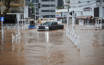 A car drives on a flooded road in the northern city of Nahariya on January 8, 2020. (Meir Vaknin/Flash90)