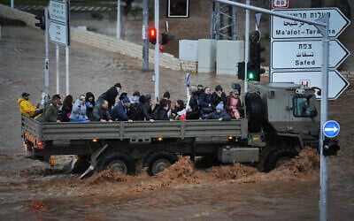 A military vehicle carries people across a flooded road in the northern city of Nahariya on January 8, 2020. (Meir Vaknin/Flash90)
