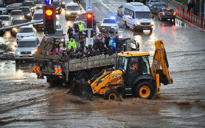 A military truck evacuates Israeli citizens through a flooded road in the northern city of Nahariya on a stormy winter day, January 8, 2020. (Meir Vaknin/Flash90)