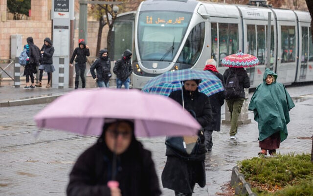 People take cover from the rain during a rainy and windy weather in Beit Hakerem neighborhood in Jerusalem, on January 8, 2020. (Yonatan Sindel/Flash90) People take cover from the rain during a rainy and windy weather in Beit Hakerem neighborhood in Jerusalem, on January 8, 2020. (Yonatan Sindel/Flash90)