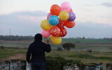 A bunch of balloons attached to an incendiary device is prepared to be flown into Israel, near the Israel-Gaza border east of Al-Bureij refugee camp in the central Gaza Strip, January 22, 2020. (Ail Ahmed/ Flash90)