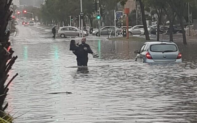 A woman is rescued by police from flooding in Ashdod, January 9, 2020 (Israel Police) A woman is rescued by police from flooding in Ashdod, January 9, 2020 (Israel Police)