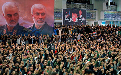 Worshipers in Iran chant slogans during Friday prayers ceremony by a banner showing slain Iranian Revolutionary Guard general Qassem Soleimani, left, and Iraqi Shiite senior militia commander Abu Mahdi al-Muhandis, who were killed in Iraq in a US drone attack on January 3, and a banner which reads in Persian: 'Death To America,' at Imam Khomeini Grand Mosque in Tehran, Iran, January 17, 2020. (Office of the Iranian Supreme Leader via AP)