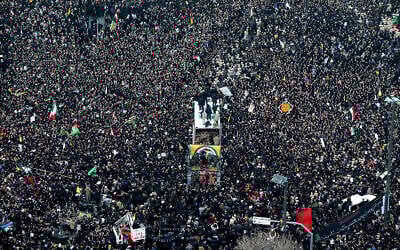 Coffins of Gen. Qassem Soleimani and others who were killed in Iraq by a US drone strike are carried on a truck surrounded by mourners during a funeral procession in the city of Mashhad, Iran, January 5, 2020. (Mohammad Hossein Thaghi/Tasnim News Agency via AP)