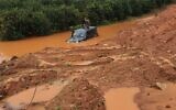 A soldier stands on the roof of his jeep after the vehicle got stuck in a deep puddle caused by recent rains in the central israeli town of Kfar Yona on January 20, 2020. (Israel Police)
