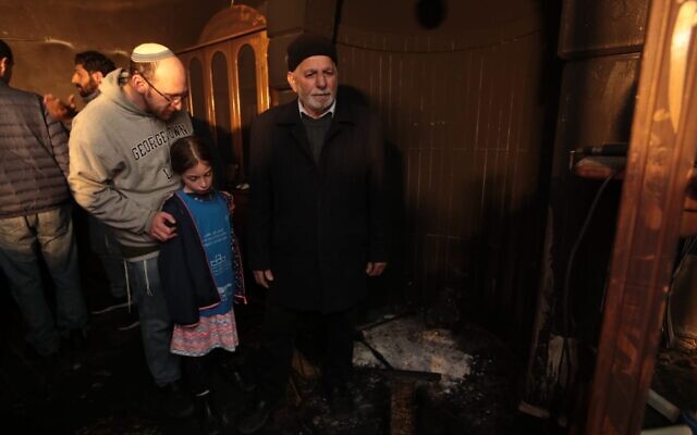 (From L) A father and his daughter stand next to Muchtar Ismail Awad during a solidarity visit to a mosque in Sharafat that was torched in an apparent hate crime on January 25, 2020. (Tag Meir) (From L) A father and his daughter stand next to Muchtar Ismail Awad during a solidarity visit to a mosque in Sharafat that was torched in an apparent hate crime on January 25, 2020. (Tag Meir)