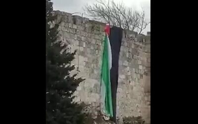 A Palestinian flag hung from the walls of Jerusalem's Old City on January 1, 2020. (screen capture: Twitter)
