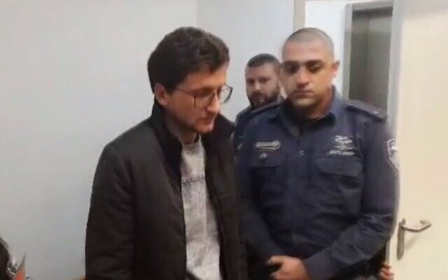 Michael Nikolkin appears at Tel Aviv District Court, accused of stabbing to death his half-brother Evgeny Kleinman, January 2, 2020 (Screen grab via Channel 12) Michael Nikolkin appears at Tel Aviv District Court, accused of stabbing to death his half-brother Evgeny Kleinman, January 2, 2020 (Screen grab via Channel 12)