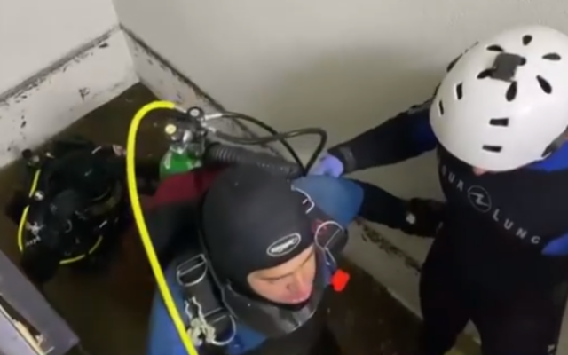 Divers seen inside a Tel Aviv building where a man and woman died Saturday due to the flooding of a basement level (Channel 13 screenshot) Divers seen inside a Tel Aviv building where a man and woman died Saturday due to the flooding of a basement level (Channel 13 screenshot)