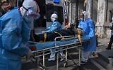 Medical staff in protective clothes are seen carrying a patient from an apartment suspected of having the virus in Wuhan, in Hubei province of China, January 30, 2020. (Photo by Hector RETAMAL / AFP)