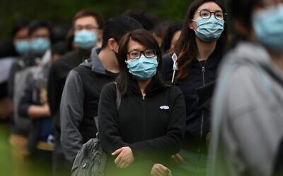 Staff members of Hong Kong's Hospital Authority queue up to sign a letter of petition in support of a planned strike by hospital workers calling for the full closure of border crossings from mainland China, near the Queen Elizabeth hospital in Hong Kong on February 4, 2020 (Anthony WALLACE / AFP)