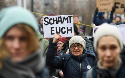One day after the election of Thuringia's State Premier, a woman holds a placard reading 'Shame on you' during a protest in front of the State Chancellery in Erfurt, eastern Germany, on February 6, 2020 (Jens Schlueter / AFP)