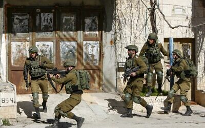 Illustrative: Israeli soldiers clash with Palestinians during a manhunt for a Palestinian man who rammed his car into IDF troops earlier in the day, in Bethlehem on February 6, 2020. (Musa Al Shaer/AFP)