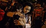 People hug each other after being rescued by Thai commandos from the Terminal 21 shopping mall, where a mass shooting took place on February 9, 2020 in the northeastern Thai city of Nakhon Ratchasima. (Lillian SUWANRUMPHA/AFP)