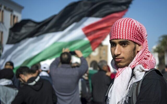 A Moroccan man walks next to a Palestinian flag during a demonstration against the US Middle East peace plan in the capital Rabat on February 9, 2020. (FADEL SENNA / AFP) A Moroccan man walks next to a Palestinian flag during a demonstration against the US Middle East peace plan in the capital Rabat on February 9, 2020. (FADEL SENNA / AFP)
