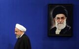Iranian President Hassan Rouhani walks past a portrait of Supreme Leader Ayatollah Ali Khamenei as he arrives for a news conference in the capital Tehran, on February 16, 2020.(Photo by ATTA KENARE / AFP)