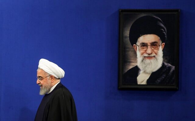 Iranian President Hassan Rouhani walks past a portrait of Supreme Leader Ayatollah Ali Khamenei as he arrives for a news conference in the capital Tehran, on February 16, 2020.(Photo by ATTA KENARE / AFP) Iranian President Hassan Rouhani walks past a portrait of Supreme Leader Ayatollah Ali Khamenei as he arrives for a news conference in the capital Tehran, on February 16, 2020.(Photo by ATTA KENARE / AFP)