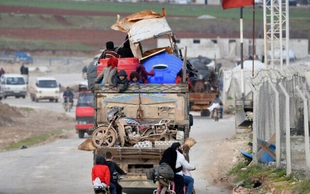 Vehicles carrying internally-displaced persons (IDPs) and their belongings drive past the IDP camp by Dayr Ballut near the Turkish border in the west of the northern Syrian province of Aleppo on February 16, 2020, as people flee advancing government forces in Idlib and Aleppo provinces. (Rami al SAYED / AFP) Vehicles carrying internally-displaced persons (IDPs) and their belongings drive past the IDP camp by Dayr Ballut near the Turkish border in the west of the northern Syrian province of Aleppo on February 16, 2020, as people flee advancing government forces in Idlib and Aleppo provinces. (Rami al SAYED / AFP)