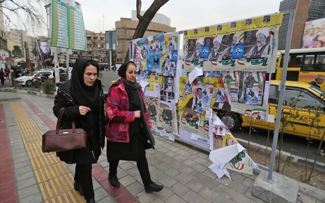 Iranian women walk past electoral posters and fliers during the last day of election campaign in Tehran on February 19, 2020. (ATTA KENARE / AFP) Iranian women walk past electoral posters and fliers during the last day of election campaign in Tehran on February 19, 2020. (ATTA KENARE / AFP)