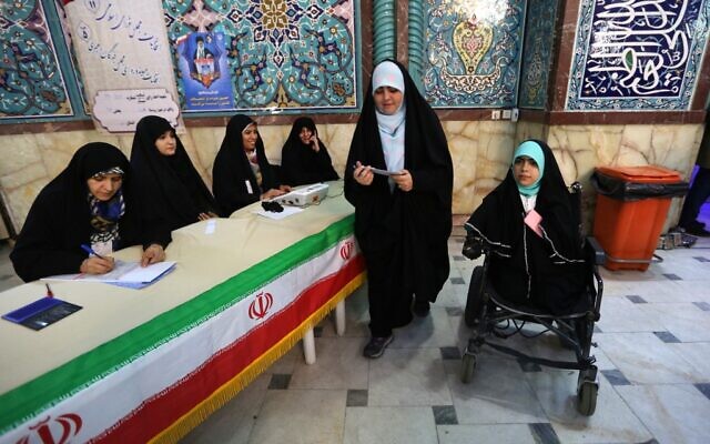 Iranian voters check a list of candidates before casting their ballot during parliamentary election at a polling station in Tehran on February 21, 2020. (Photo by ATTA KENARE / AFP) Iranian voters check a list of candidates before casting their ballot during parliamentary election at a polling station in Tehran on February 21, 2020. (Photo by ATTA KENARE / AFP)