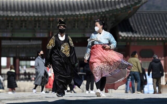 People in traditional Korean hanbok dresses wear face masks as they visit Gyeongbokgung palace in Seoul on February 23, 2020 (Jung Yeon-je / AFP) People in traditional Korean hanbok dresses wear face masks as they visit Gyeongbokgung palace in Seoul on February 23, 2020 (Jung Yeon-je / AFP)
