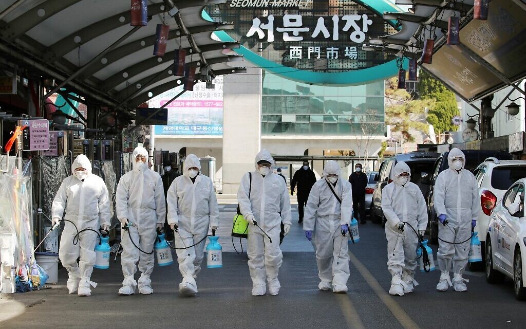 Market workers wearing protective gear spray disinfectant at a market in the southeastern city of Daegu, South Korea, on February 23, 2020, as a preventive measure after the COVID-19 coronavirus outbreak. (YONHAP / AFP) Market workers wearing protective gear spray disinfectant at a market in the southeastern city of Daegu, South Korea, on February 23, 2020, as a preventive measure after the COVID-19 coronavirus outbreak. (YONHAP / AFP)