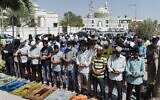 Muslim worshippers, some wearing protective masks, perform together Friday prayers outside a mosque in Bahrain's capital Manama on February 28, 2020. (Mazen Mahdi/AFP)