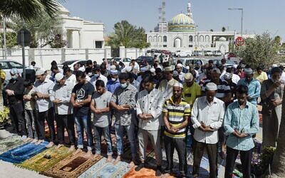 Muslim worshippers, some wearing protective masks, perform together Friday prayers outside a mosque in Bahrain's capital Manama on February 28, 2020. (Mazen Mahdi/AFP)