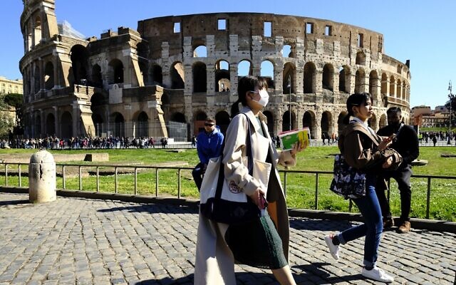 Tourists wearing a protective respiratory mask tour outside the Colosseum monument in downtown Rome on February 28, 2020 amid fear of Covid-19 epidemic (Andreas SOLARO / AFP) Tourists wearing a protective respiratory mask tour outside the Colosseum monument in downtown Rome on February 28, 2020 amid fear of Covid-19 epidemic (Andreas SOLARO / AFP)