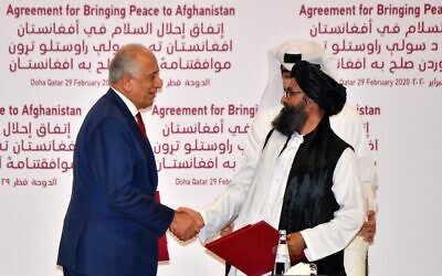 US Special Representative for Afghanistan Reconciliation Zalmay Khalilzad, left, and Taliban co-founder Mullah Abdul Ghani Baradar shake hands after signing a peace agreement during a ceremony in the Qatari capital Doha on February 29, 2020. (Giuseppe Cacace/AFP)