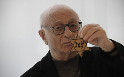 In this photo taken on Thursday Jan. 30, 2020, Victor Perahia, interned as a child in the Drancy camp and deported to Bergen-Belsen shows a Jewish badge as he speaks to students during a workshop dedicated to the Holocaust remembrance at the Drancy Shoah memorial, outside Paris (AP Photo/Christophe Ena)