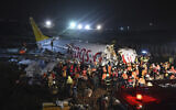 Rescue members and firefighters work around the wreckage of a plane after it skidded off the runway at Istanbul's Sabiha Gokcen Airport, in Istanbul, February 5, 2020. (Ismail Coskun/IHA via AP)