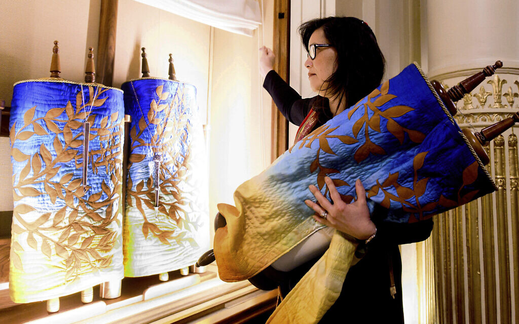 In this February 1, 2020, photo, Rabbi Jacqueline Mates-Muchin removes a Torah scroll from the ark, a cabinet that houses scrolls of the Hebrew Bible, while preparing for Shabbat morning service at Temple Sinai in Oakland, California (AP/Noah Berger) In this February 1, 2020, photo, Rabbi Jacqueline Mates-Muchin removes a Torah scroll from the ark, a cabinet that houses scrolls of the Hebrew Bible, while preparing for Shabbat morning service at Temple Sinai in Oakland, California (AP/Noah Berger)