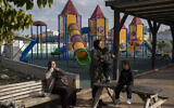In this Thursday, Feb. 6, 2020, photo, Israeli Arabs enjoy the day at a playground in the Israeli Arab town Kafr Qasim (AP Photo/Oded Balilty)