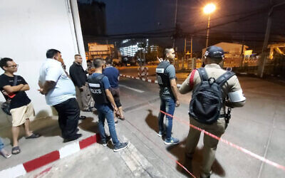 Police and bystanders stand near the scene of a shooting at the Terminal 21 mall, in Korat, Thailand,  Saturday, Feb. 8, 2020. (AP Photo)