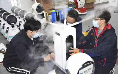 In this photo released by Xinhua News Agency, technicians work on a second generation disinfection robot in a technological company in Qingdao, eastern China's Shandong Province on February 11, 2020. (Li Ziheng/Xinhua via AP) In this photo released by Xinhua News Agency, technicians work on a second generation disinfection robot in a technological company in Qingdao, eastern China's Shandong Province on February 11, 2020. (Li Ziheng/Xinhua via AP)