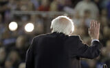 US Democratic presidential candidate Sen. Bernie Sanders Independent-Vermont, is lit by spotlights as he speaks at a campaign event in Tacoma, Washington, February 17, 2020. (Ted S. Warren/AP)
