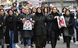 In this February 21, 2020, photo, friends and relatives hold up photos of victims of a shooting, in Hanau, Germany. (AP Photo/Martin Meissner, File)