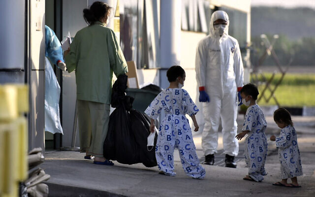 In this photo taken and released by Malaysia's Ministry of Health, a health worker looks at a woman and children arrive at Kuala Lumpur International Airport in Sepang, Malaysia, Wednesday, Feb. 26, 2020, after being evacuated from China's Wuhan, the epicenter of the coronavirus outbreak. (Muzzafar Kasim/Malaysia's Ministry of Health via AP) In this photo taken and released by Malaysia's Ministry of Health, a health worker looks at a woman and children arrive at Kuala Lumpur International Airport in Sepang, Malaysia, Wednesday, Feb. 26, 2020, after being evacuated from China's Wuhan, the epicenter of the coronavirus outbreak. (Muzzafar Kasim/Malaysia's Ministry of Health via AP)