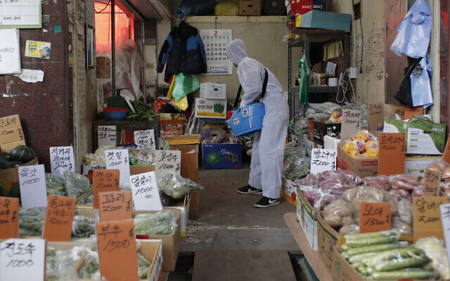 A worker wearing a protective suit sprays disinfectant as a precaution against the COVID-19 at a market in Seoul, South Korea, Wednesday, Feb. 26, 2020. (AP Photo/Lee Jin-man) A worker wearing a protective suit sprays disinfectant as a precaution against the COVID-19 at a market in Seoul, South Korea, Wednesday, Feb. 26, 2020. (AP Photo/Lee Jin-man)