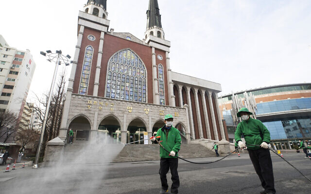 Workers wearing face masks spray disinfectant as a precaution against the new coronavirus in front of Myungsung Church in Seoul, South Korea, Wednesday, Feb. 26, 2020. (Yun Dong-jin/Yonhap via AP) Workers wearing face masks spray disinfectant as a precaution against the new coronavirus in front of Myungsung Church in Seoul, South Korea, Wednesday, Feb. 26, 2020. (Yun Dong-jin/Yonhap via AP)