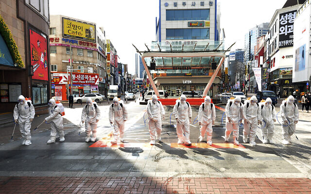 South Korean army soldiers wearing protective suits spray disinfectant to prevent the spread of the COVID-19 virus on a street in Daegu, South Korea, Feb. 27, 2020 (Lee Moo-ryul/Newsis via AP) South Korean army soldiers wearing protective suits spray disinfectant to prevent the spread of the COVID-19 virus on a street in Daegu, South Korea, Feb. 27, 2020 (Lee Moo-ryul/Newsis via AP)
