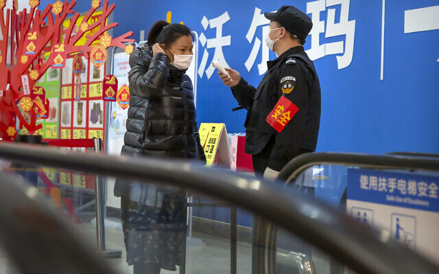 A security guard takes a customer's temperature at the entrance to a grocery store in Beijing, February 1, 2020. (AP Photo/Mark Schiefelbein) A security guard takes a customer's temperature at the entrance to a grocery store in Beijing, February 1, 2020. (AP Photo/Mark Schiefelbein)